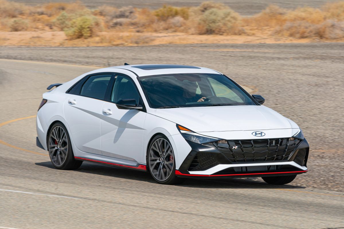 Hyundai Elantra N in white with red accents, front three-quarter press photo on a desert road